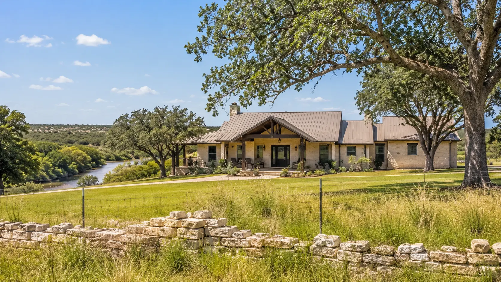 Stone ranch home with covered porch overlooking the South Concho River near Christoval, Texas